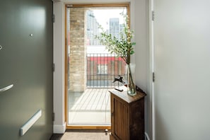 Enter a tranquil space with a sliding glass door leading to a balcony offering a city view.