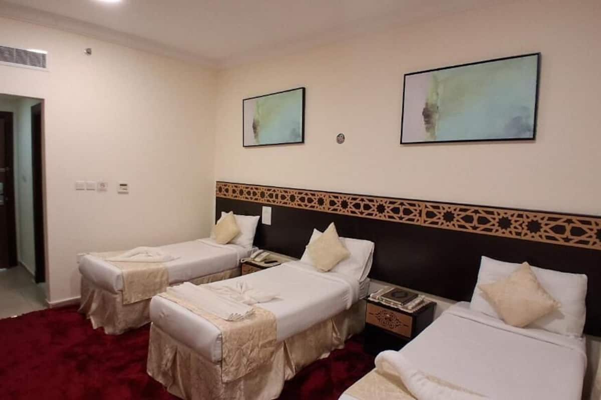 Ein Hotelzimmer mit zwei Einzelbetten, einem roten Teppich und einem dekorativen Kopfteil.