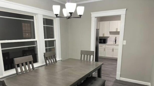 A dining area with a rectangular table, benches, and a chandelier. - Shaker Ohio contemporary home!

 (Cleveland)