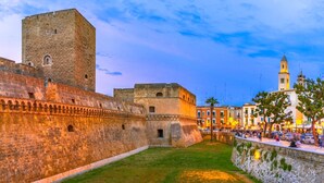 Un'antica fortezza in pietra con una torre centrale e un muro perimetrale.