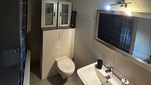 A bathroom with a toilet, a sink, and a cabinet. - Quiet apartment 4 min from the cathedral with office and balcony (Köln)