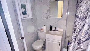 Une salle de bain avec des toilettes, un lavabo et un miroir.