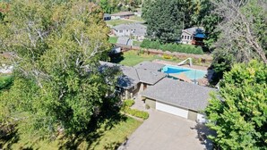 A residential area with houses, a swimming pool, and surrounding greenery.