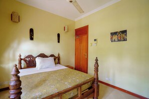 Une chambre à coucher avec un lit en bois, une tête de lit en bois, une porte et une œuvre d’art accrochée au mur.