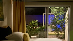 Una camera da letto con un letto, una finestra con tende e vista sull'esterno.