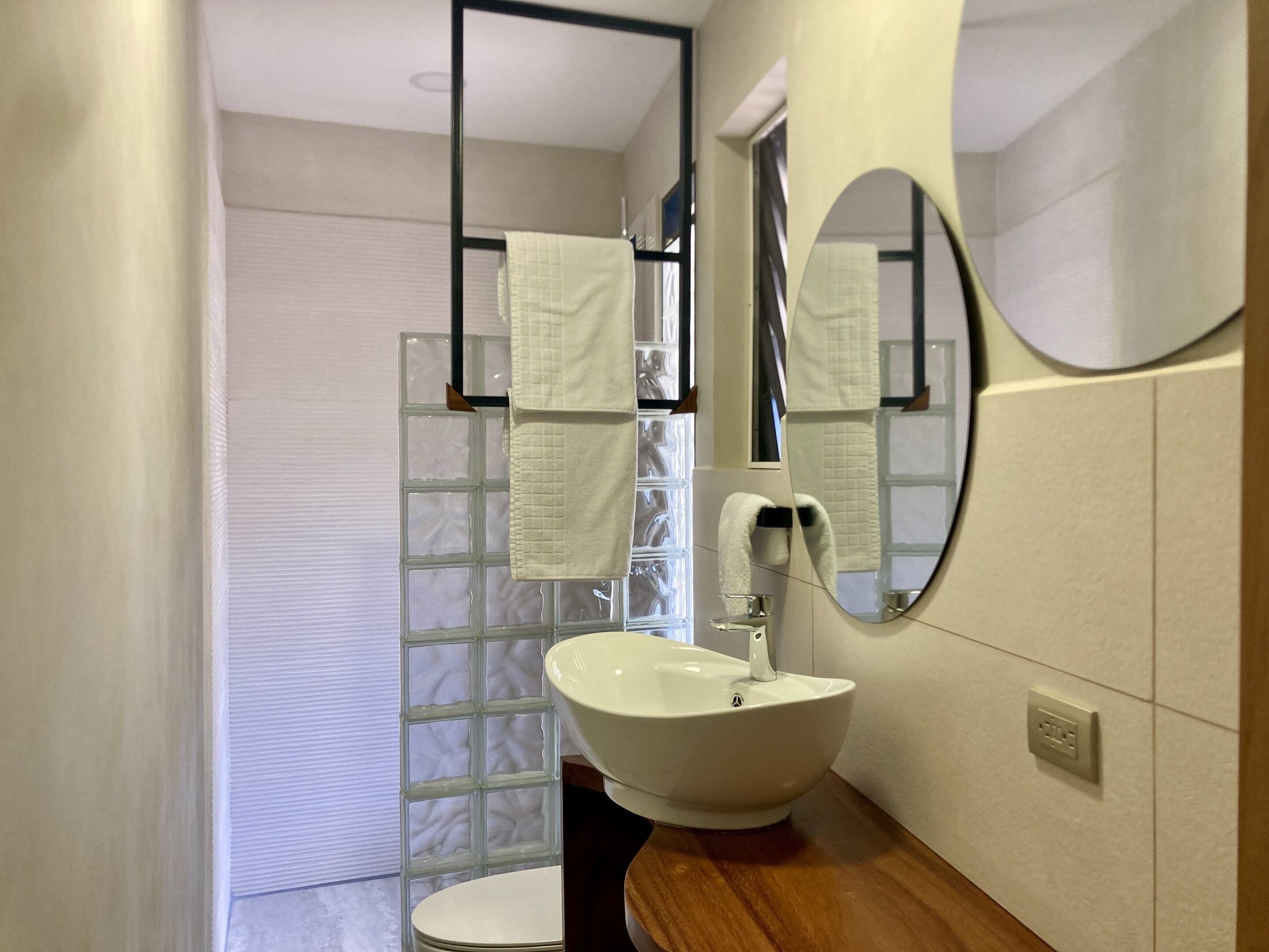 A bathroom with a white sink, a mirror, and a towel rack.