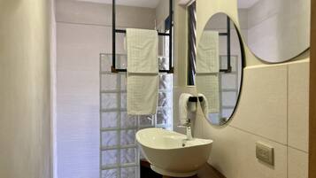 A bathroom with a white sink, a mirror, and a towel rack.