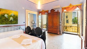 A hotel room with two beds, a large mirror, and a view of the outside balcony. - Palazzo Insula (Gallipoli)