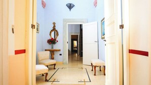 A hallway with an arched ceiling, a mirror, a chair, and a bench. - Palazzo Insula (Gallipoli)