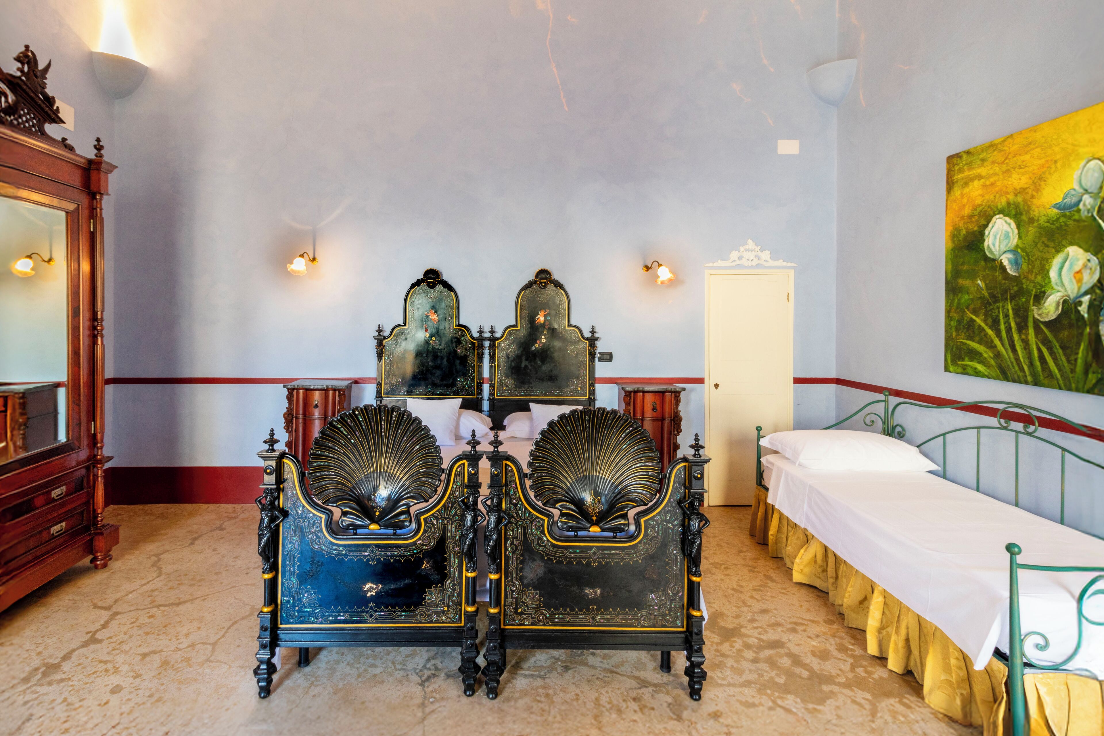 A room with a bed, a wooden dresser, a mirror, and a painting on the wall.