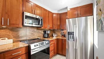 This glossy wood-toned kitchen feels like a warm hug—where coffee brews strong, and breakfasts come with a tropical twist