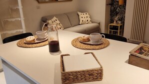 Una cocina moderna con una isla central, armarios blancos y un espejo decorativo sobre la encimera.