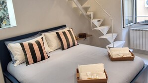 Un dormitorio moderno con una cama grande, una escalera y una ventana.