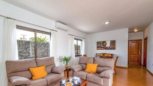 Ein Wohnzimmer mit zwei Sofas, einem Couchtisch und einem Essbereich mit Tisch und Stühlen.