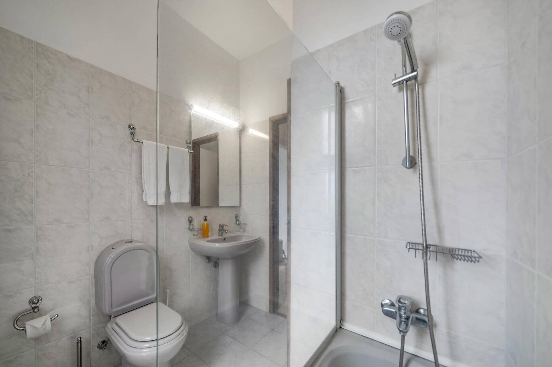 Ein modernes Badezimmer mit Toilette, Waschbecken und Dusche.