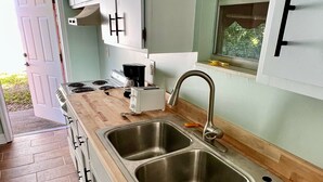 A kitchen with two stainless steel sinks, a wooden countertop, and white cabinets. - Pet & Large Boat OK 1 Bed Studio Near Marina & Beach Private Lot  Sleeps 2 (Fort Pierce)