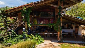 A rustic building with a covered patio area, outdoor seating, and a garden with various plants. - Villa Deluxe 9 rooms - 30 minutes from Tamarindo & 5 minutes from Playa Negra (Playa Negra)