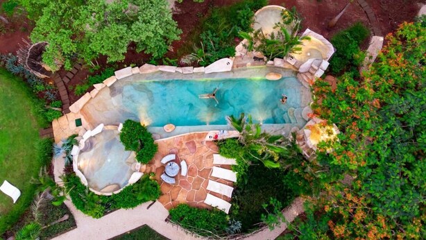 An aerial view of a landscaped swimming pool area with a hot tub, lounge chairs, and a stone pathway. - Villa Deluxe 9 rooms - 30 minutes from Tamarindo & 5 minutes from Playa Negra (Playa Negra)