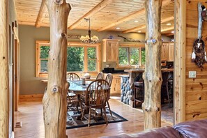 L’intérieur d’une cabane comprend un coin repas, une cuisine et une cheminée en pierre.