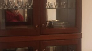 Un meuble en bois doté de portes en verre, contenant divers objets.
