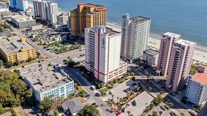 An aerial view of a coastal city with high-rise buildings, a beach, and a parking area. - Carolina Grande (Myrtle Beach)