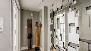 A hallway with a wooden door, a mirror wall, and a sign.
