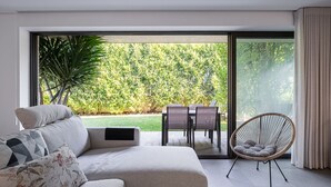 Ein modernes Wohnzimmer mit einer Couch, einem Sessel und einem Esstisch.