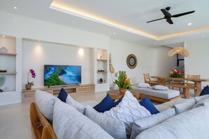 Relax in this stylish living room with a flat-screen TV, comfortable sofa, and dining area.