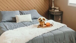 Una camera da letto con un letto, un comodino, una lampada e una finestra.