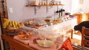 Een buffetopstelling met diverse soorten eten en een decoratieve muur.