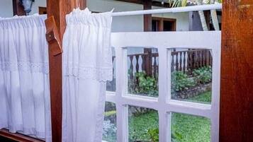 Una ventana con cortinas blancas y marco de madera.