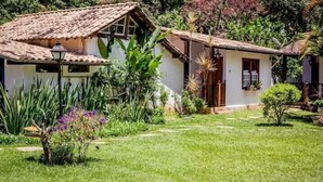 Een klassiek huis met pannendak, omringd door weelderig groen en een verzorgd gazon.