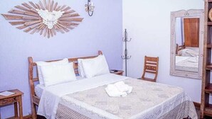 Een kamer met een bed, een tafel en een spiegel.
