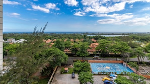 An aerial view of a residential area with a basketball court, surrounded by trees and houses with red-tiled roofs. - Luxury in Barra da Tijuca Near the Olympic Park Av806 (Rio de Janeiro)