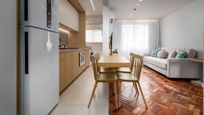 A modern kitchen with a built-in refrigerator, wooden cabinets, and a dining area with a table and chairs. - Luxury in Barra da Tijuca Near the Olympic Park Av806 (Rio de Janeiro)