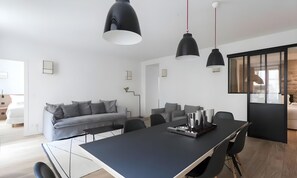 A modern interior with a dining table, chairs, and a sofa.