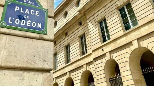 Un edificio con un cartel que indica "Place de Lodeon" y una farola.