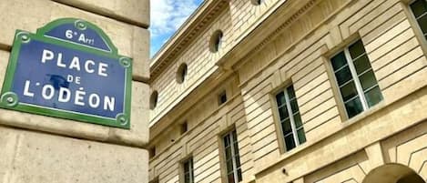 Un edificio con un cartel que indica "Place de Lodeon" y una farola.