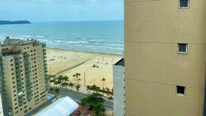 A high-rise building with a beach view, a clear sky, and a calm sea. - Residencial Acquamare (Praia Grande)