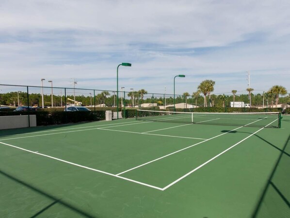 An outdoor tennis court with green flooring and white boundary lines. - Phoenix IV 4112 (Orange Beach)