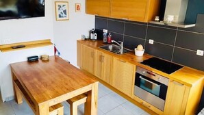 A compact kitchen with wooden cabinets, a built-in oven, and a small sink.