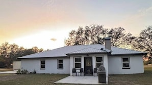 A single-story house with a front porch, a chimney, and a small front yard. - The Bunkhouse at Origins Ranch (Plant City)