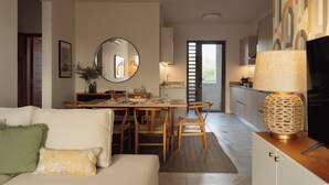 A modern living room with a dining area, a kitchen, and a large mirror. - Luxury apartment in Flic en Flac (Flic en Flac)