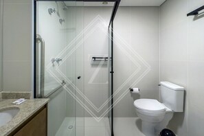 Bathroom features a glass-enclosed shower with handheld showerhead and control panel, toilet, granite countertop, and towel rack.