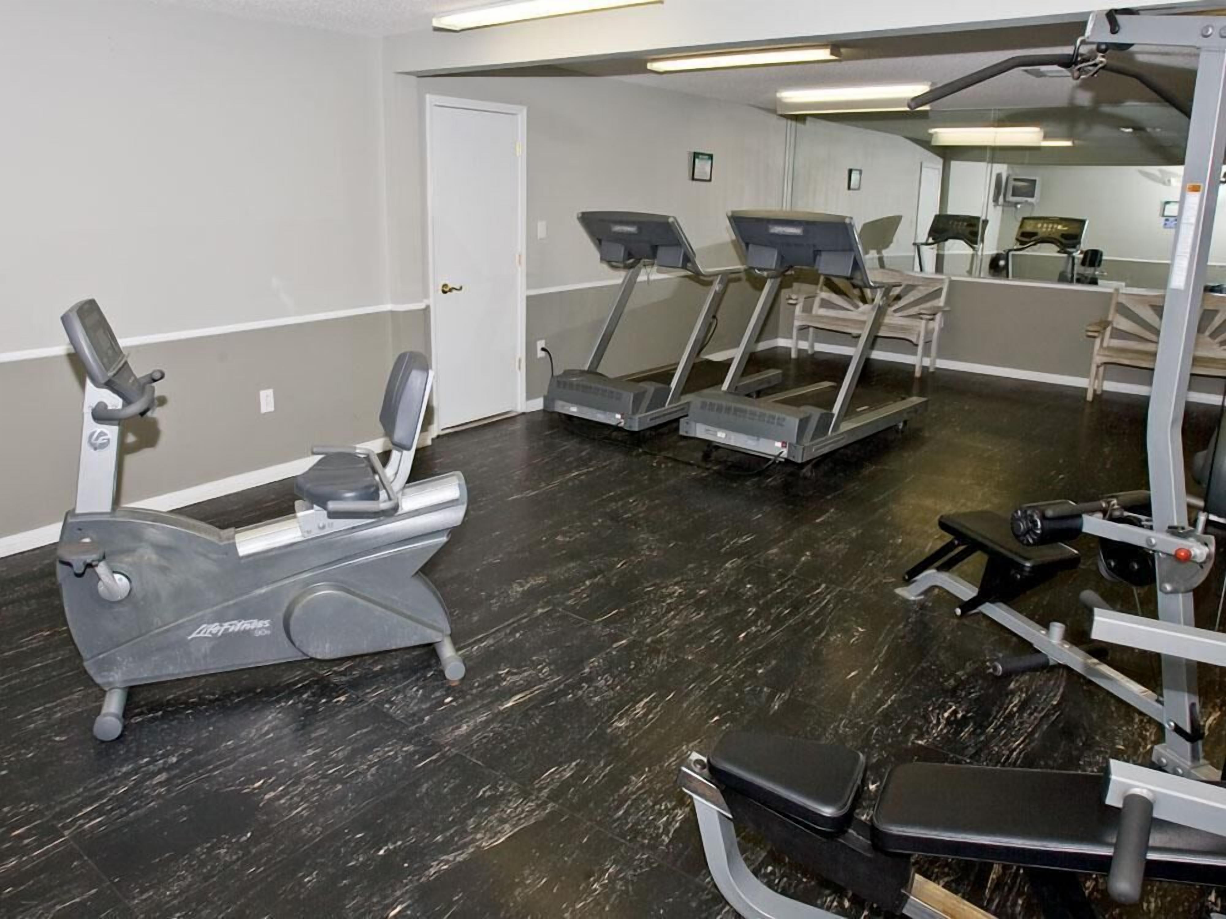 A gym with treadmills, an elliptical, and weight machines.