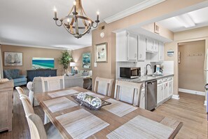 A modern kitchen with white cabinets, a stainless steel dishwasher, and a microwave. - Seascape 22a- Hello Sunshine (Miramar Beach)