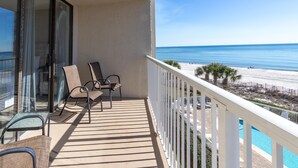 A balcony with a view of the beach, a pool, and a glass door leading to a room. - Seaside Beach & Racquet 3401 (Orange Beach)