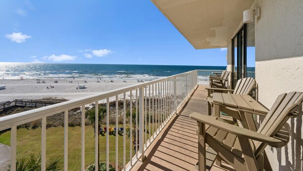 Een balkon met uitzicht op het strand en de oceaan.