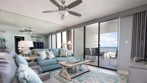 A modern living room with a sofa, coffee table, and a balcony with a view. - Seaside Beach & Racquet 4708 (Orange Beach)