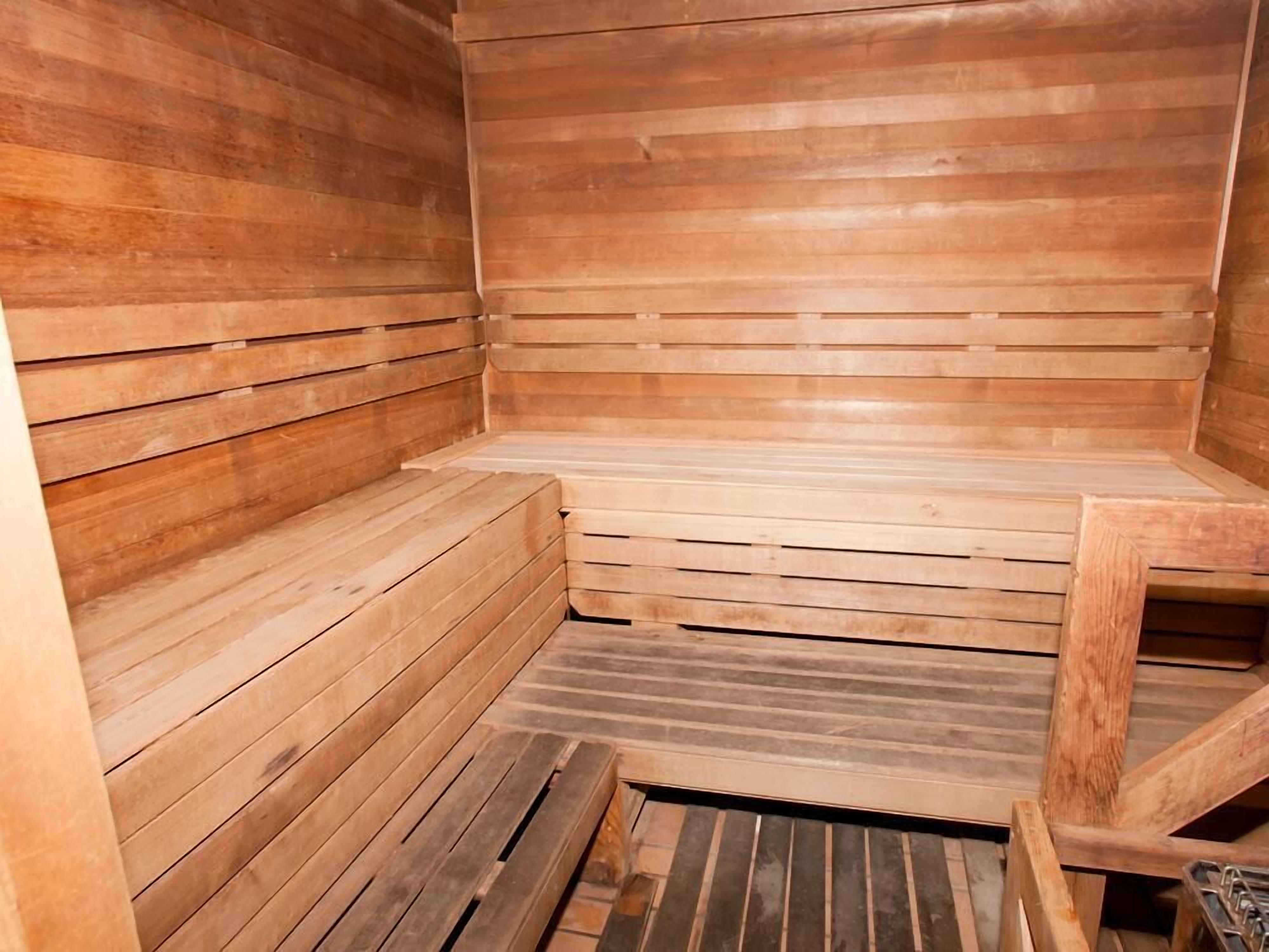 A wooden sauna with benches and a slatted floor.